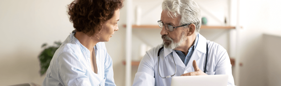 Älterer Arzt berät Patientin