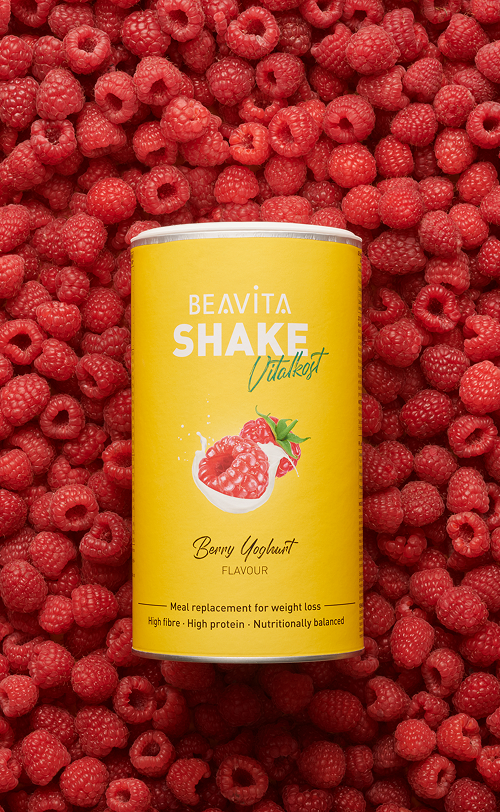 BEAVITA Diät-Shake mit Himbeere-Joghurt-Geschmack und frische Himbeeren im Hintergrund