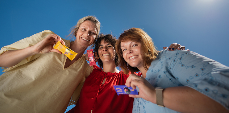 Fröhliche Frauen mit Snacks in der Hand