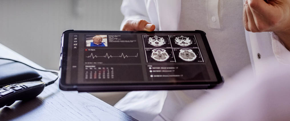 
Arzt/Ärztin hält Tablet mit medizinischen Daten in der Hand.