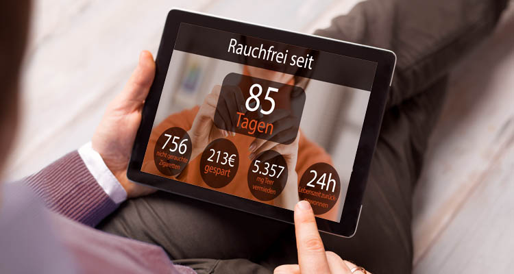 Eine Person hält ein Tablet, auf dem angezeigt wird: „Rauchfrei seit 85 Tagen“ mit weiteren Erfolgsstatistiken.