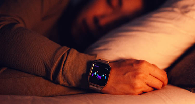 Hand hält Smartphone mit Gesundheits-App, die Schritte, Kalorien und Aktivitätszeit anzeigt, im Hintergrund frisches Gemüse und Salat auf Holzbrett.