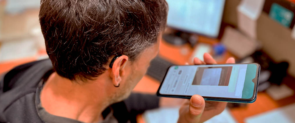 Mann hat ein Smartphone in der Hand.