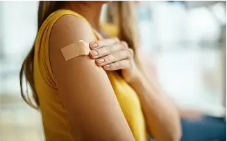 Frau bekommt Pflaster auf den Arm.