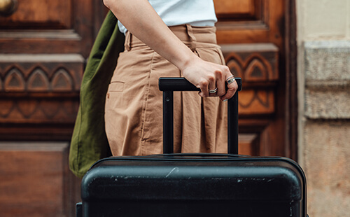 Eine Frau schiebt einen Koffer.