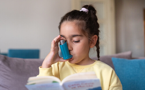 Ein Mädchen inhaliert und liest dabei ein Buch. 