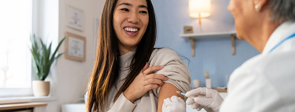 Eine Frau erhält eine Impfung in den Oberarm.