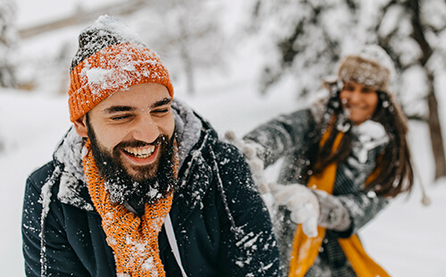 Ein lachendes Pärchen im Schnee.