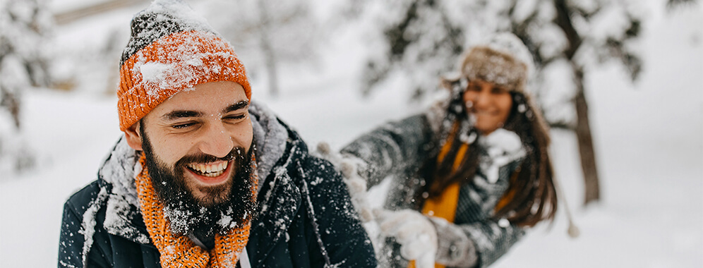 Ein lachendes Pärchen im Schnee.