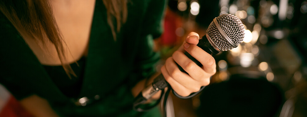 Eine Frau hält ein Mikrofon in der Hand.