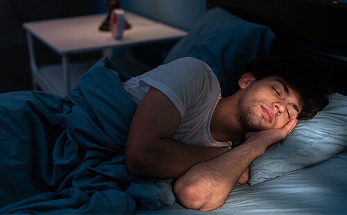 Ein Mann liegt im Bett und schläft.