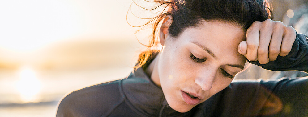 Eine Frau war draußen in Bewegung und legt den Kopf auf ihrem Arm ab.