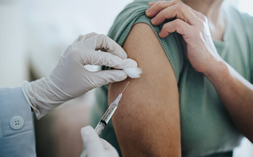 Eine Frau bekommt eine Spritze in den Oberarm. 