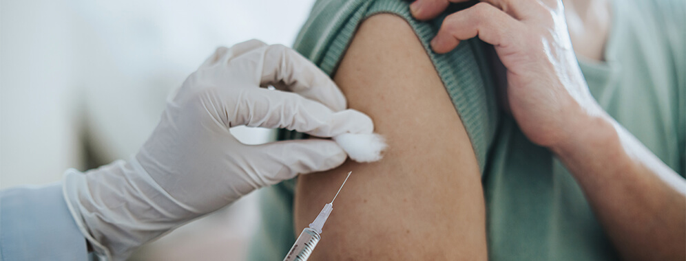 Eine Frau bekommt eine Spritze in den Oberarm.