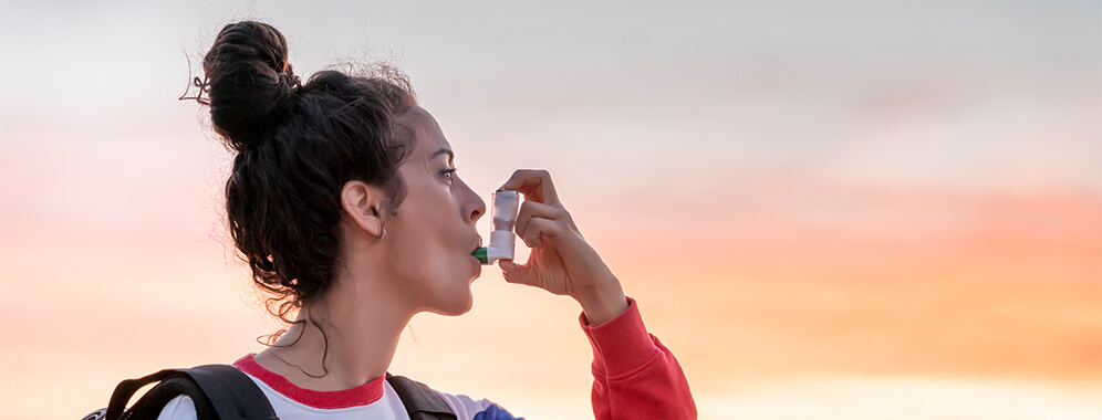 Eine Frau benutzt ein Inhaliergerät.