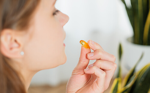 Eine Frau nimmt eine Tablette ein. 