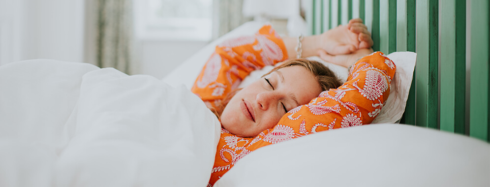 Eine Frau liegt im Bett und schläft.