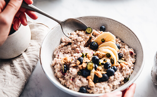 Man sieht eine Bowl mit Porridge und Obst