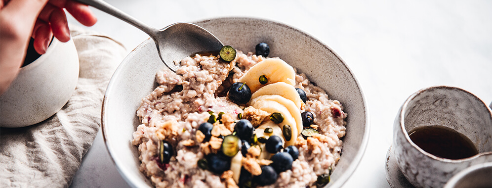Man sieht eine Bowl mit Porridge und Obst.