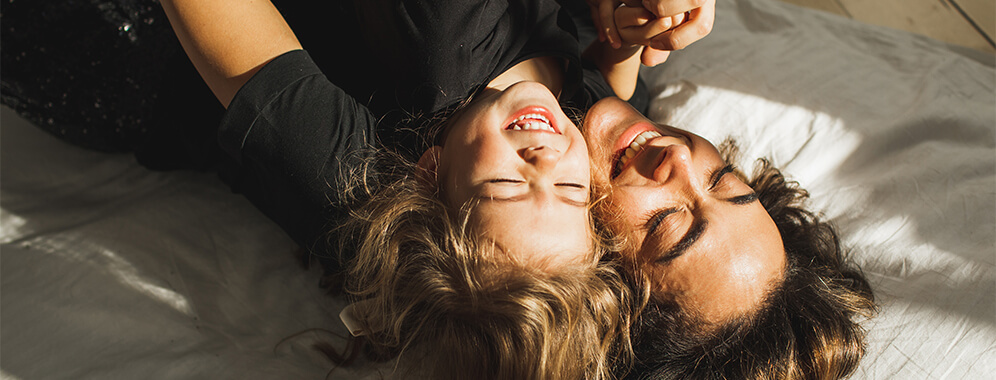 Eine Frau kuschelt mit ihrer Tochter.