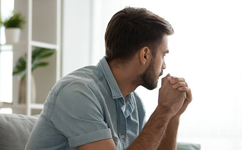 Ein Mann blickt nachdenklich zur Seite. 