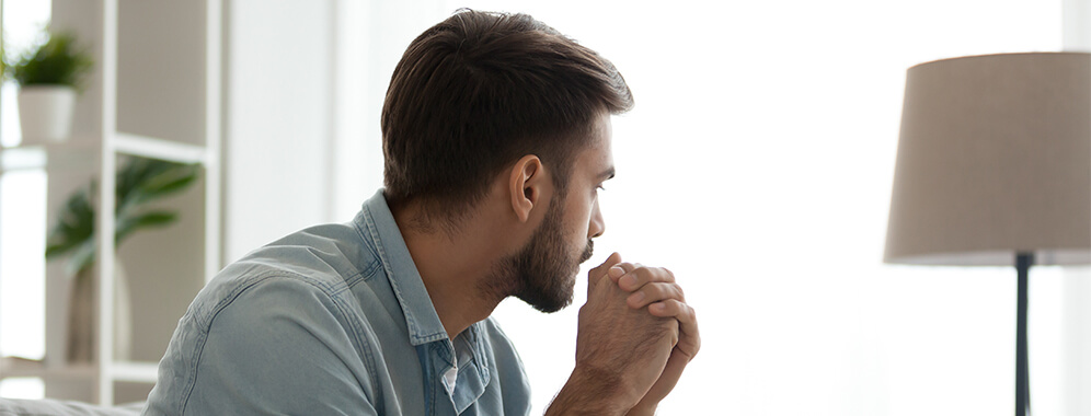 Ein Mann schaut nachdenklich zur Seite. 