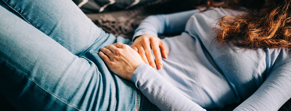 Eine Frau hält ihren Bauch.