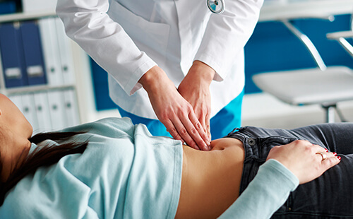 Eine Frau wird am Bauch untersucht. 