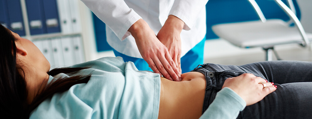 Eine Frau wird am Bauch untersucht. 