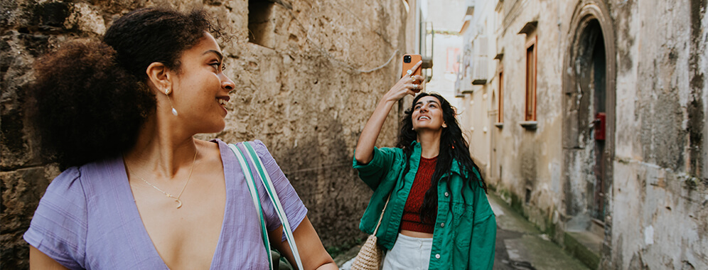 Zwei Frauen gehen durch eine alte Stadt.