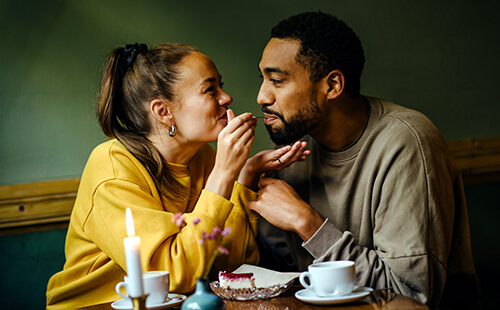 Eine Frau füttert spielerisch ihren Mann. 