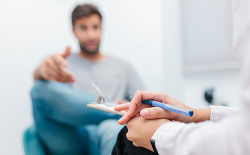 Ein Mann im Gespräch mit dem Arzt. 