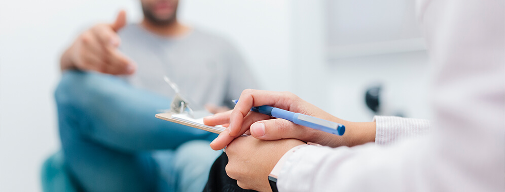 Ein Mann im Gespräch beim Arzt. 