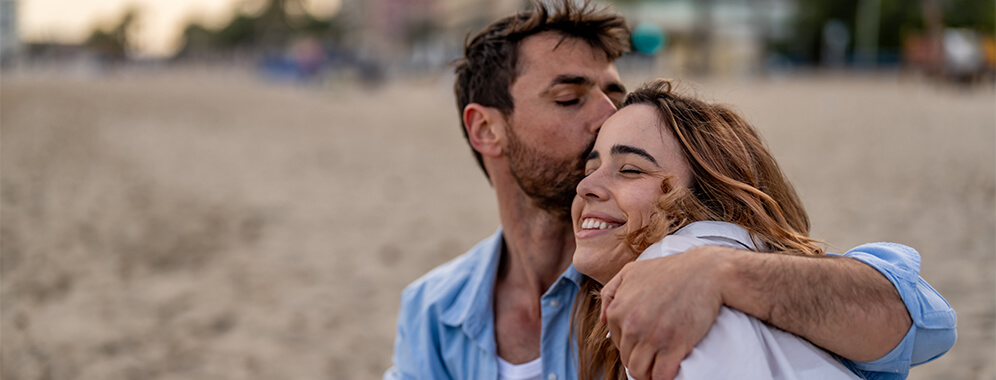 Ein Mann umarmt und küsst eine Frau.