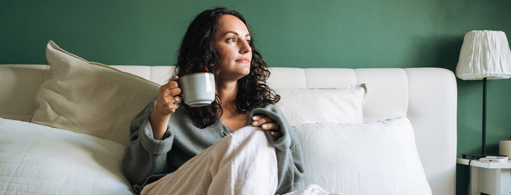 Eine Frau mit einer Tasse in der Hand. 