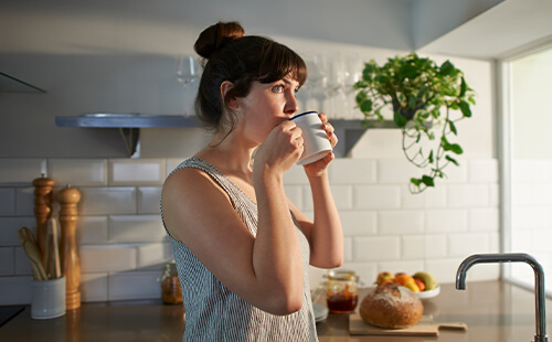 Eine Frau trinkt aus einer Tasse.