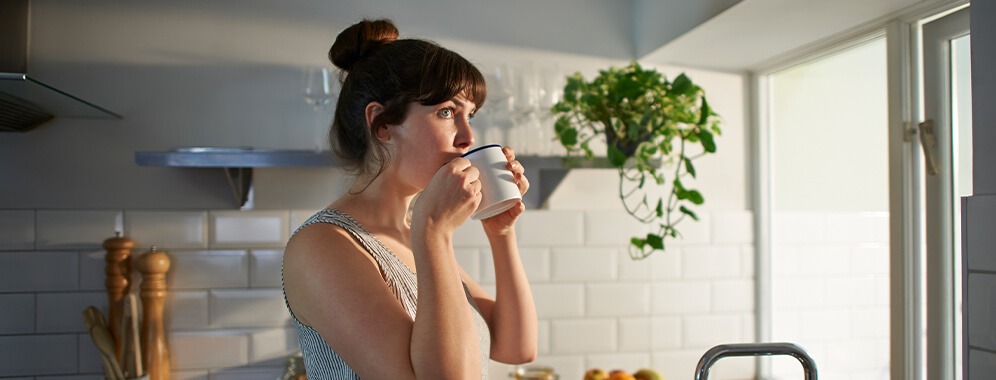 Eine Frau trinkt aus einer Tasse.