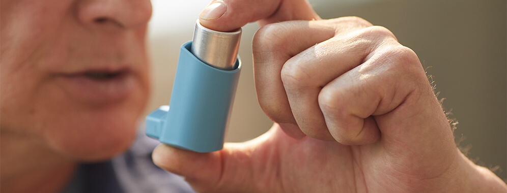 Ein Mann benutzt einen Inhalator.