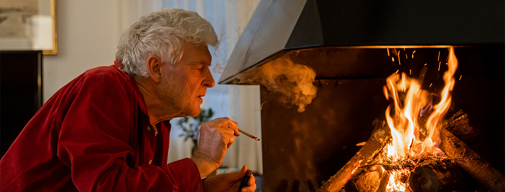 Ein Mann raucht am Kamin.