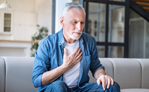Ein Mann hält sich die Brust.