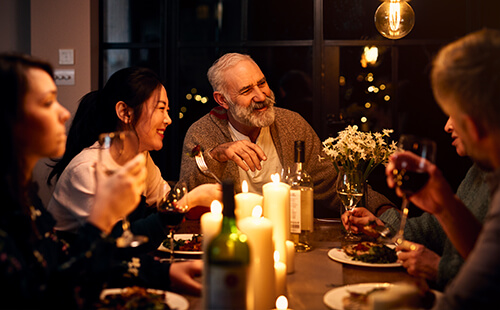 Ein Mann sitzt mit seiner Familie am Tisch.