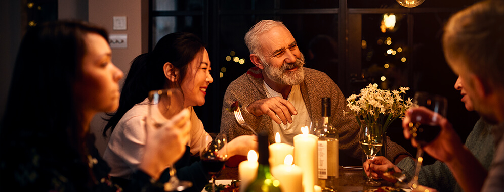 Ein Mann sitzt mit seiner Familie zusammen am Tisch.