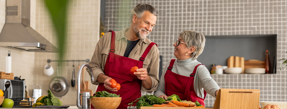 Zwei Personen stehen in der Küche und bereiten Essen zu.