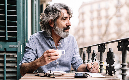 Ein Mann trinkt Kaffee auf dem Balkon.
