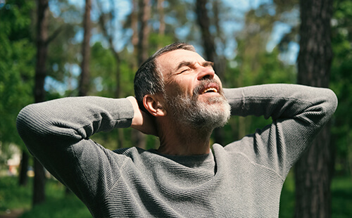 Ein Mann streckt sich in der Sonne. 