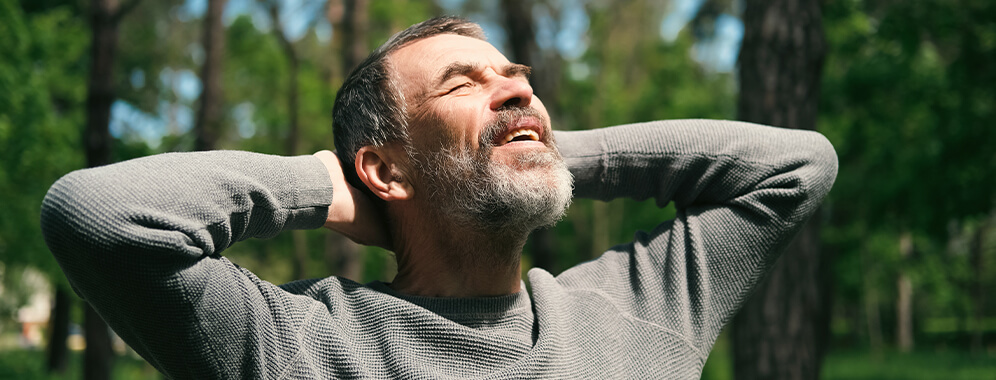 Ein Mann streckt sich im Sonnenschein. 