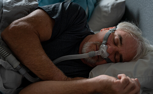 Ein Mann schläft mit Schlafmaske.