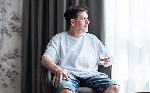 Älterer Herr trinkt Wasser.