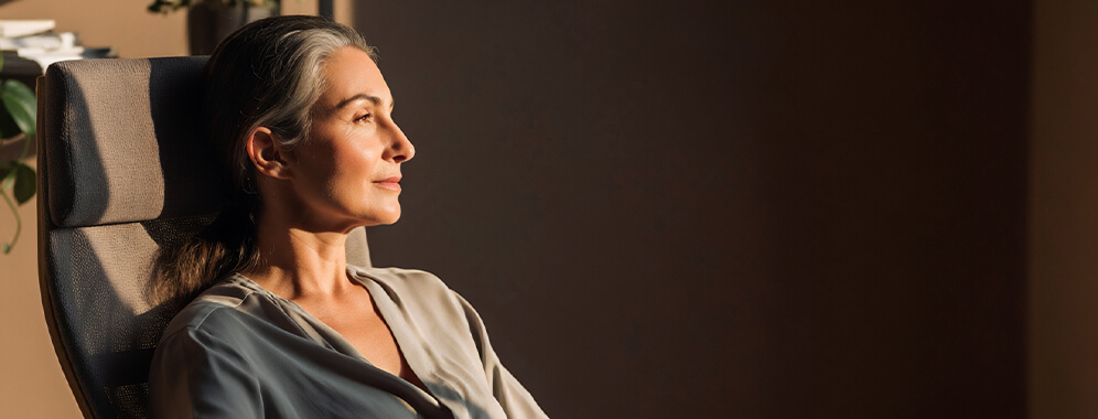 Eine Frau sitzt im Sessel.