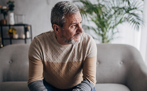 Ein Mann blickt nachdenklich zur Seite. 